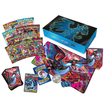 A Pokémon TCG starter-style display set on a white background, including a large blue Charizard-themed box, multiple booster packs, a large playmat, a coin, dice, and cards.