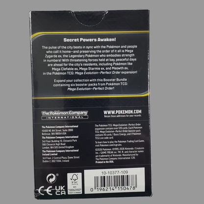 The back of a black product box with white text, a barcode, and small yellow accent lines, photographed on a white surface.