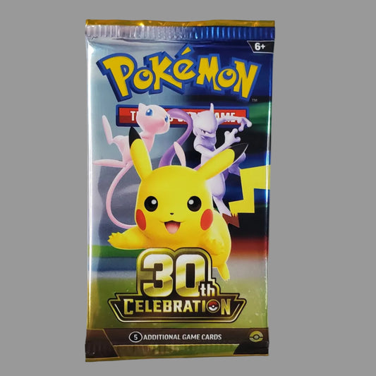 A Pokémon booster pack featuring Pikachu and other Pokémon on the front, hanging against a white wall above a desk with a keyboard visible at the bottom.