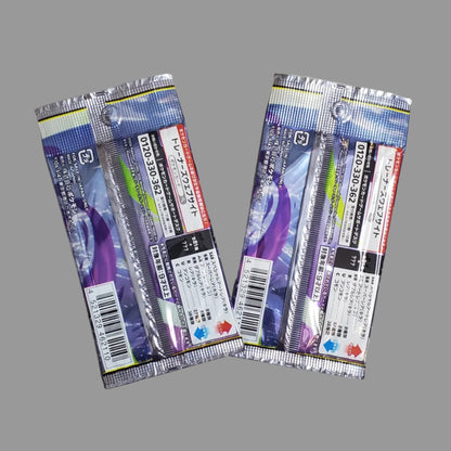 Two packaged fishing line spools or fishing line packages lying on a light gray floor. The packages are silver and purple with Japanese text and barcode labels.