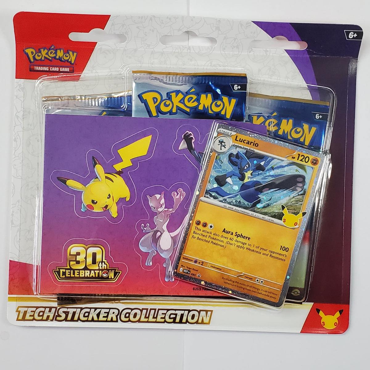 three booster collection blister packs with Pokemon character stickers, Lucario promo card in a purple, white, and red container on a white background.