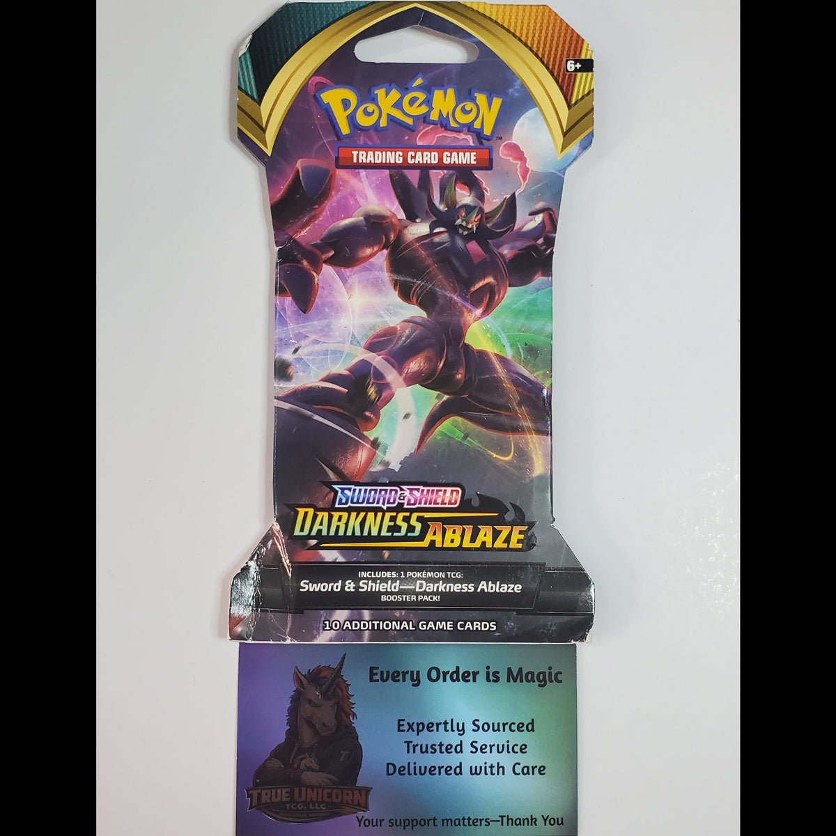 Pokémon Trading Card Game Darkness Ablaze booster pack with a promotional insert card below it, photographed against a plain light background.