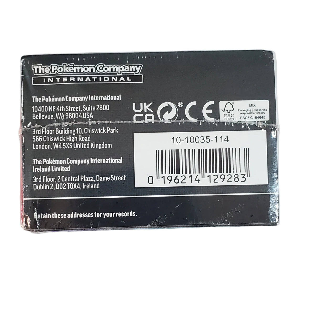 The back of a The Pokémon Company International product box in black, placed above a blue and purple thank-you card on a plain white background.