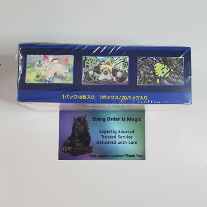 A blue rectangular product box wrapped in clear plastic, shown on a white background with a small card in front that reads 'Every Order is Magic' and shows a dark cat illustration.