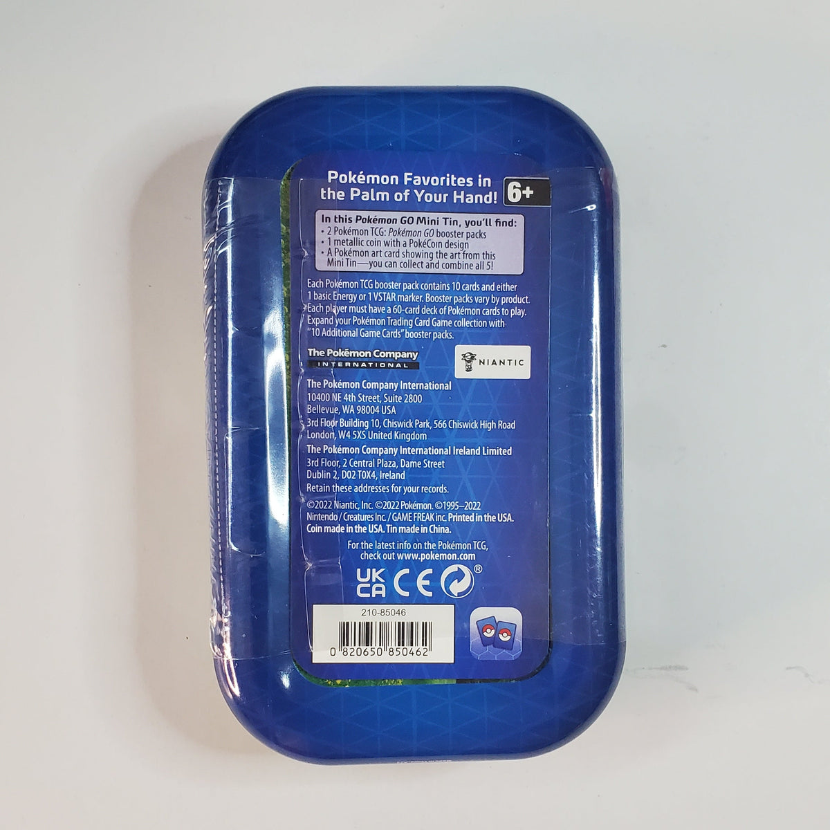 A blue plastic container with a printed white and blue product information label on the back, photographed on a plain white surface.