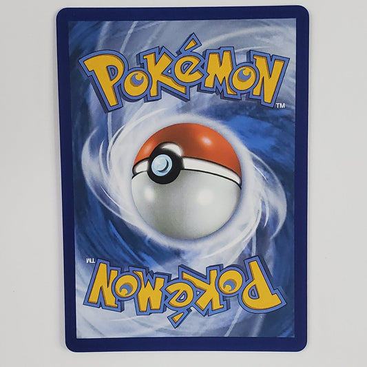 A Pokémon card featuring the classic blue back design with a large Pokémon Ball in the center and yellow 'Pokémon' text, photographed against a plain white wall.