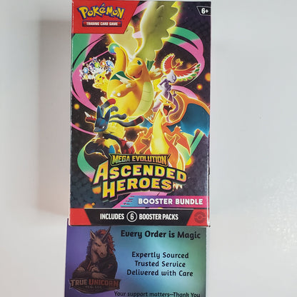 Pokémon TCG 'Ascended Heroes' booster bundle box featuring colorful artwork of a yellow dragon and other characters on a dark background, photographed standing upright against a plain light wall.
