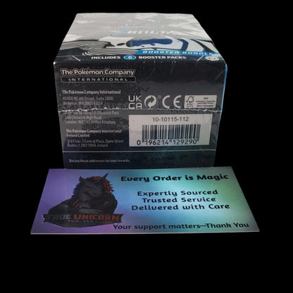 A boxed collectible item from The Pokémon Company sits on a white surface, with a printed card in front showing promotional text and artwork for 'The Unicorn'.