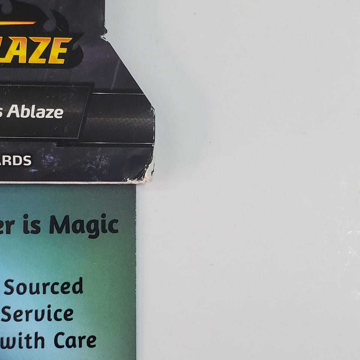 A close-up of a Magic: The Gathering card box labeled 'Ablaze' and 'Order is Magic' against a plain light gray background.