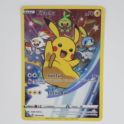 A Pokémon trading card featuring Pikachu with Electro Ball, displayed against a plain white wall above a white surface with partial keyboard edges visible at the bottom.