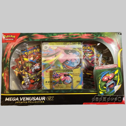 Pokémon MEGA VENUSUR GX Mega Battle Collection booster pack box with visible booster packs and cards inside, photographed on a gray textured fabric background.